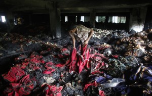 Një punëtor midis mbetjeve në një fabrikë të djegur në Dhaka, në Bangladesh. (Andrew Biraj, Reuters/Contrasto)